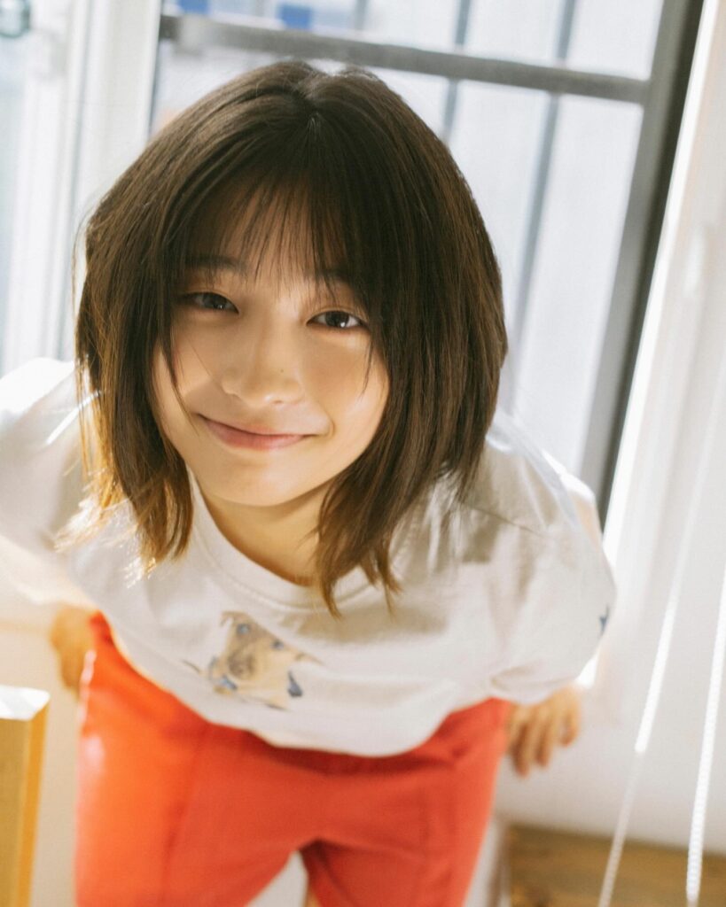 ショートボブの沢田京海さんが白いTシャツ姿でこちらに微笑みかけている写真。