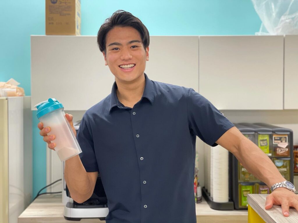 プロテイン用ドリンクのボトルを片手に笑顔で写真に写る山本アナ。