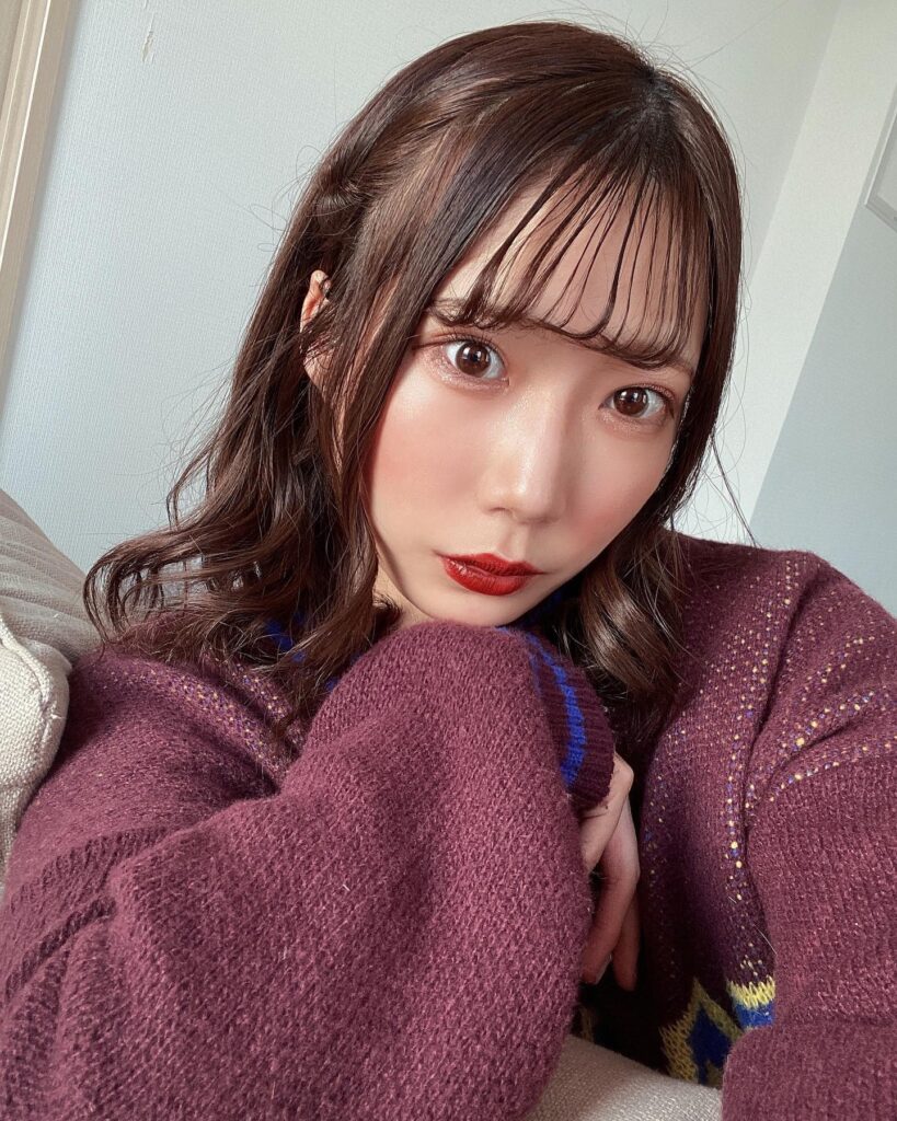 紫色のニットを着て自撮りをするあーてぃん